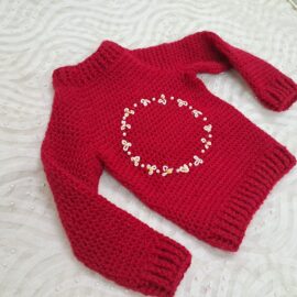 Crochet handmade baby sweater with hand embroidery.